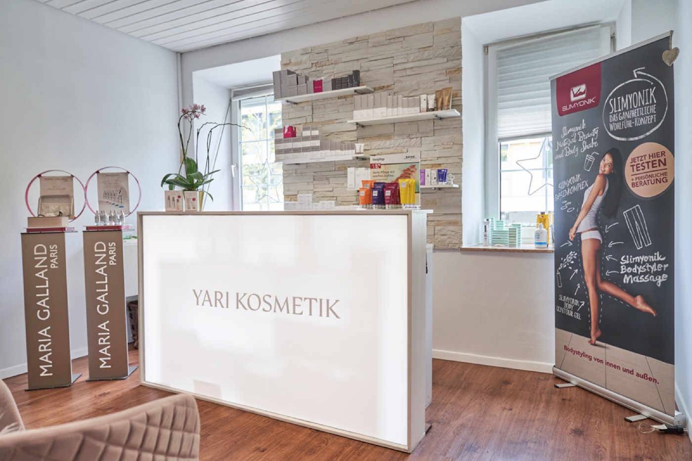 Empfangsbereich von Yari Kosmetik mit beleuchtetem Tresen und dem Schriftzug Yari Kosmetik.
